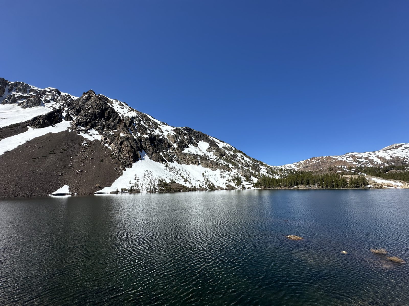 Snow-rimmed alpine lake at Ellery Lake near Tioga Pass