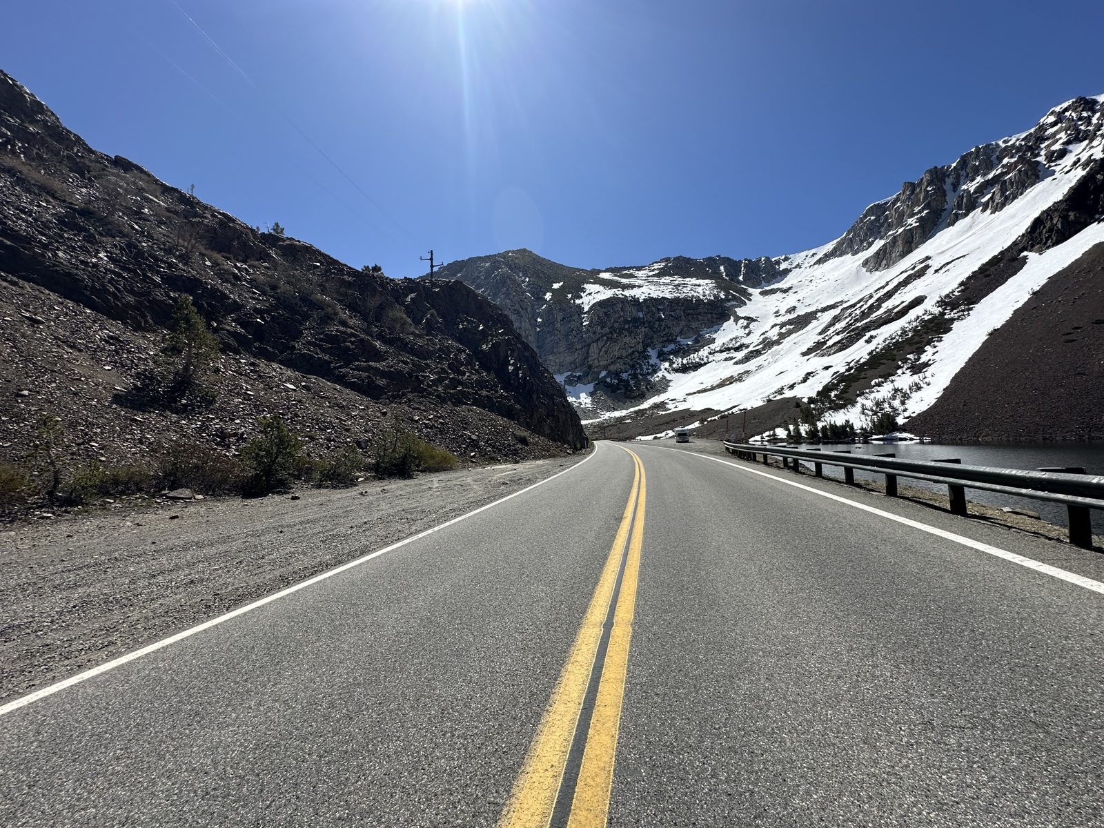 Highway 120 climbing toward snowy peaks at Tioga Pass